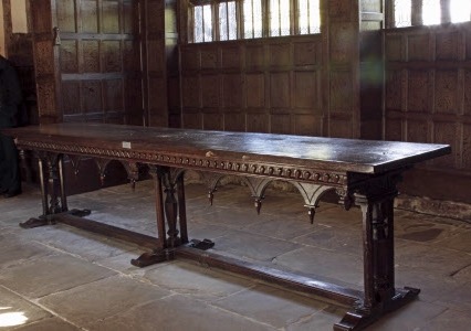 Oak refectory table, the top being original (possibly late 15th century), the frame of late 18th or 19th century date and having a round arcade with bosses below the spandrels. The top is mounted on three supports with a single stretcher running lengthways (appearing to be a later addition). The top of the frame has six pendant bosses at regular intervals carved with Ionic capitals.